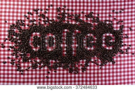 Coffee Beans Forming The Word Coffee On A Red And White Checkered Background.