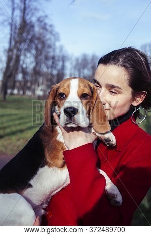 Pretty Young Girl In Redd Coat Playing With Dog Outside In Green Park, Lifestyle People Concept