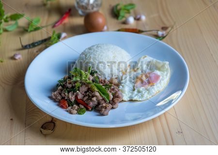 Rice Topped Of Food Rice Topped With Stir-fried Pork And Basil On Wood Background.  Thai  Street Foo