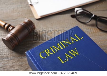 Gavel And Book On Wooden Table. Criminal Law Concept