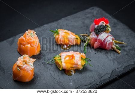 Sushi, Traditional Japanese Cuisine. Several Delicious Sushi On The Decorated Plate, Black Backgroun