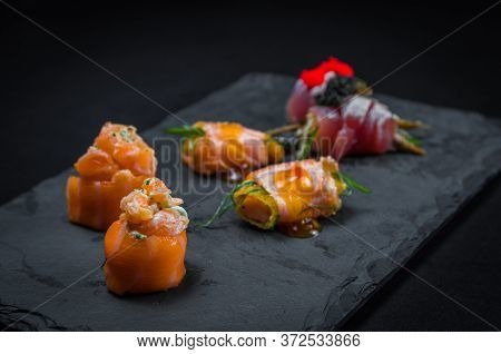 Sushi, Traditional Japanese Cuisine. Several Delicious Sushi On The Decorated Plate, Black Backgroun