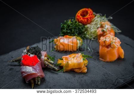 Sushi, Traditional Japanese Cuisine. Several Delicious Sushi On The Decorated Plate, Black Backgroun
