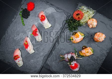 Sushi, Traditional Japanese Cuisine. Several Delicious Sushi On The Decorated Plate, Black Backgroun