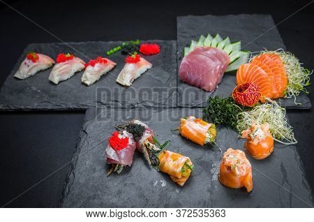 Sushi, Traditional Japanese Cuisine. Several Delicious Sushi On The Decorated Plate, Black Backgroun