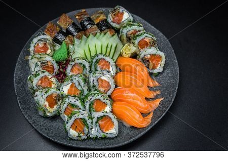 Sushi, Traditional Japanese Cuisine. Several Delicious Sushi On The Decorated Plate, Black Backgroun