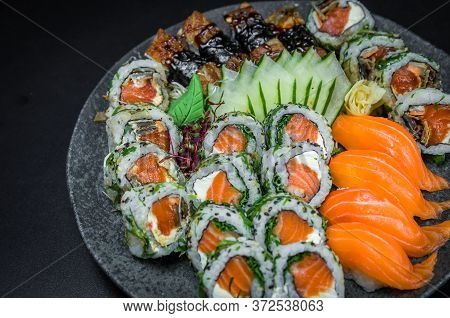 Sushi, Traditional Japanese Cuisine. Several Delicious Sushi On The Decorated Plate, Black Backgroun