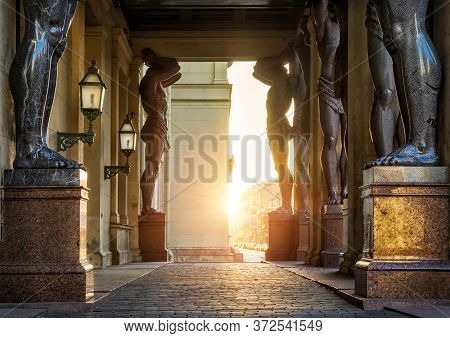 Several Atlanteans Propping Up The Arch Of The Hermitage Museum Building Stand In St. Petersburg In 