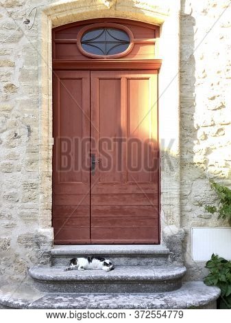 Cat Sleeping Over A Ancient Arched Roman Door And Stone Stairs