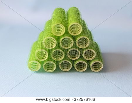 Hair Culers On The Blue Backround. Green Culers For Hairdress Stacked In A Pyramid. Top View.
