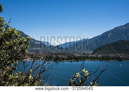Beautiful View Of Lake Garda From The Ponale Road, With The Blue Sky, Sailing Boats, And The Green O