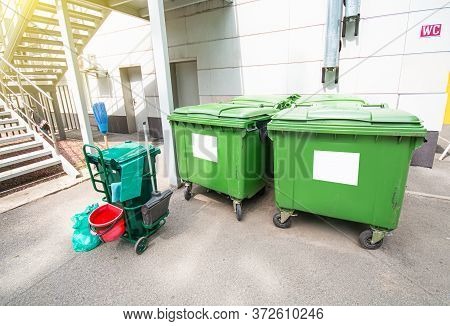 Garbage Cans On The Street Near The Public Wc. City Streets Cleaning Background.