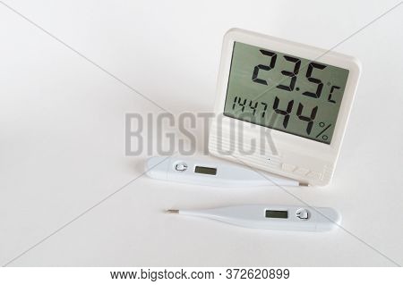 Two Digital Medical Thermometers And A Household White Thermometer
