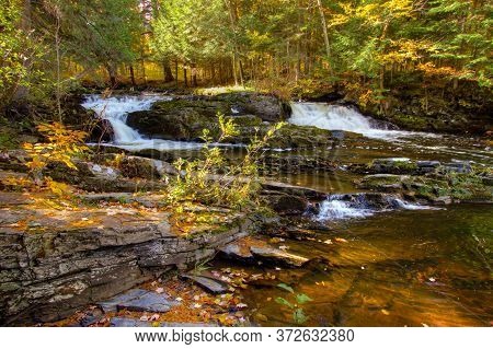 Double Waterfall With Fall Foliage On The Falls River In The Small Town Of  In The Upper Peninsula O