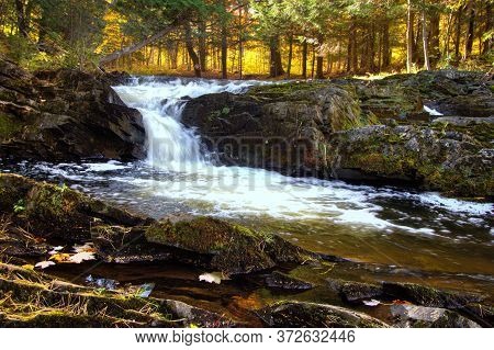 Autumn Waterfall With Fall Foliage On The Falls River In The Small Town Of L'anse In The Upper Penin