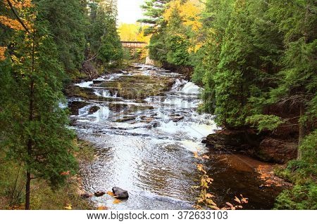 Double Waterfall With Fall Foliage On The Falls River In The Small Town Of L'anse In The Upper Penin