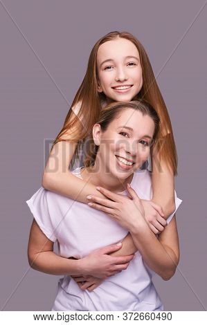 Elder Mother And Teenager Daughter Hug. Happy Family Portrait. Similar Smile. Next Generation Love. 