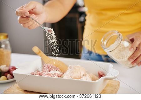 Woman Putting Some Spoons Of Bread Crumps Into The Bowl With Ground Beef