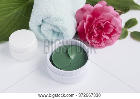Hydrogel Patches To Care For And Moisturize The Skin Around The Eye, Flowers And Towel. The Concept 