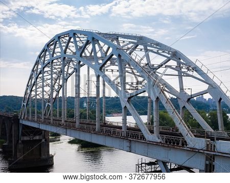 Span Of The Railroad Bridge With Steel Riveted Arch Truss Over The River. Fragment Of The Darnytskyi