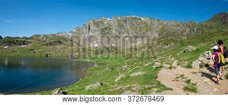 Two Hiker Women In Path Of The Ayous Lake In The French Pyrenees Mountains