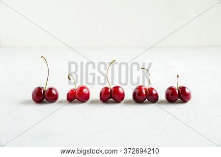 Ugly Red Cherries On The White Background. Trendy Shaped Food. Misshapen Produce, Food Waste Problem