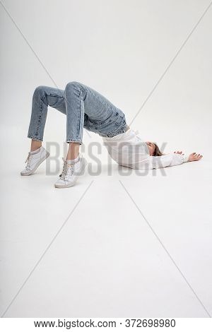 Portrait Of Young Caucasian Pretty Woman In Shirt, Jeans, Isolated On White Studio Background Lying 