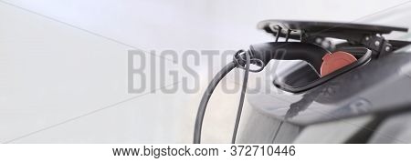 Clopse-up Of Electric Car Being Charged. Panoramic Image With Copy Space.