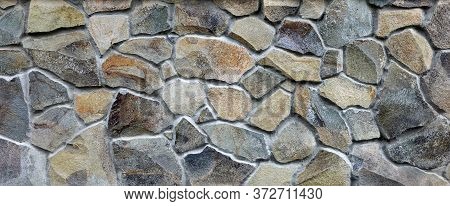 Stone Wall Texture Of Different Forms Stones. Wall Cladding With Granite Stones.