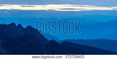 Spectacular View Of Blue Mountain Ranges Silhouettes And Fog In Valleys. Julian Alps, Triglav Nation