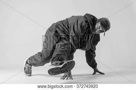 A Man Hip Hop Dancer Or Bboy Freezes In One Pose On A White Background. Bboy Doing Stylish Stunts.