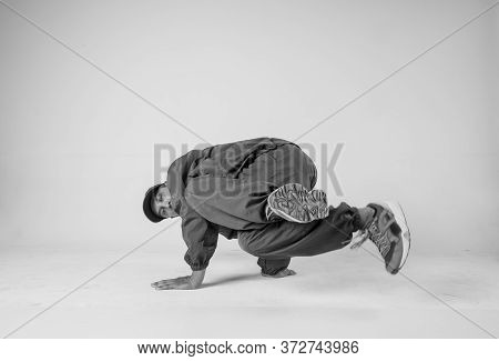 A Man Hip Hop Dancer Or Bboy Freezes In One Pose On A White Background. Bboy Doing Stylish Stunts.