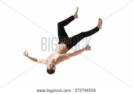 Mid-air Beauty Cought In Moment. Full Length Shot Of Young Man Hovering In Air And Keeping Eyes Clos