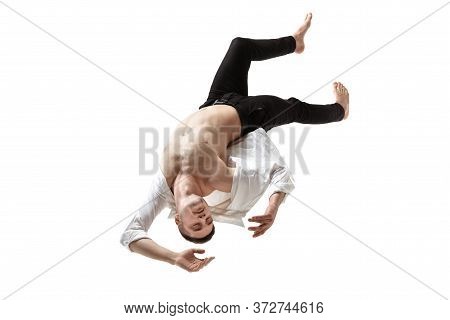 Mid-air Beauty Cought In Moment. Full Length Shot Of Young Man Hovering In Air And Keeping Eyes Clos