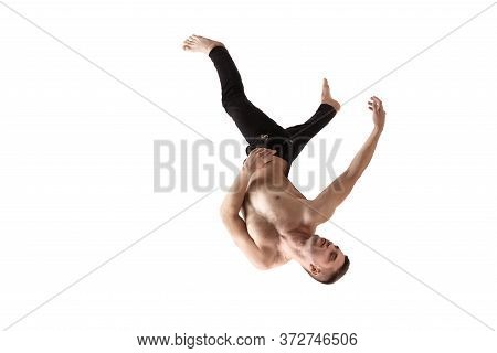 Mid-air Beauty Cought In Moment. Full Length Shot Of Young Man Hovering In Air And Keeping Eyes Clos