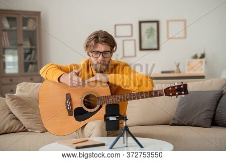 Contemporary teacher of guitar playing online course explaining main rules of learning or making introduction speech for his audience