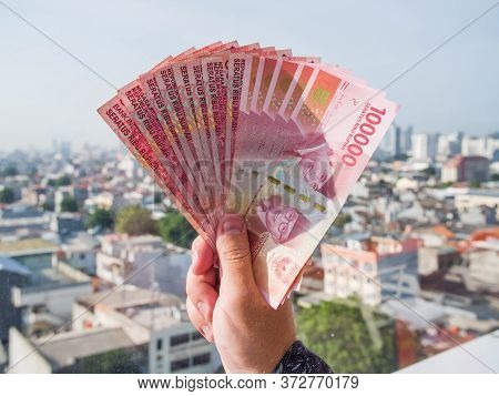 One Hundred Thousandth Indonesian Money In The Hands Of A Man.