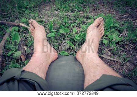 after a long hike the man stretched out his legs for rest lying on the self-inflating tourist rugs