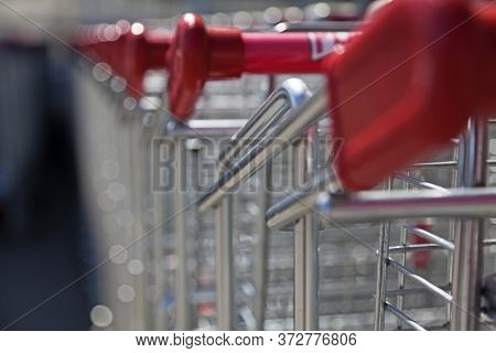A Very Long Line Of Shopping Carts With Blurry Background