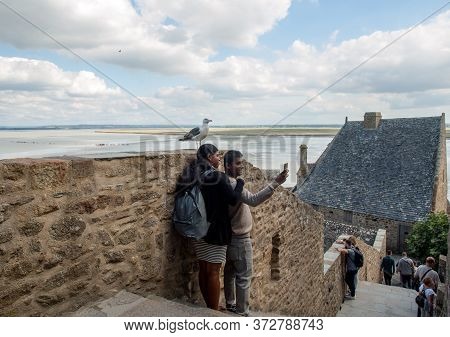 Le Mont-saint-michel, France - September 13, 2018: A Pair Of Hindus Take A Picture With A Seagull In