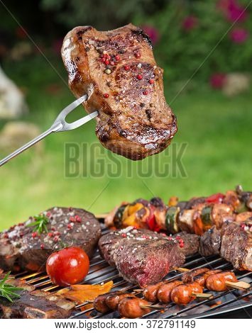 Barbecue garden grill with beef steaks, close-up.