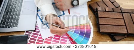 Male Designer Hand Hold Silver Pen Against Color Palette Trend Closeup Background. Building Material