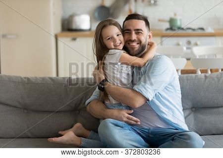 Close Up Headshot Portrait Picture Of Smiling Father Hugging Daughter.