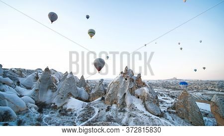 Cappadocia, Turkey - January 6, 2020: Colorful Balloons Over Volcanic Rocks In Cappadocia. Turkey.
