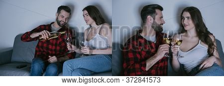 Of Happy Young Couple Holding Glasses Of White Wine While Sitting On Sofa, Horizontal Image
