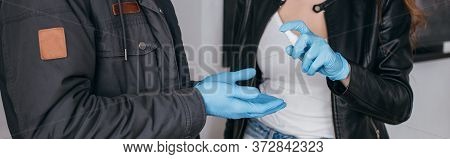 View Of Couple In Medical Masks And Latex Gloves Using Antiseptic Spray, Panoramic Shot