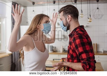 Couple In Medical Masks Quarreling While Girl Screaming And Gesturing With Raised Hands