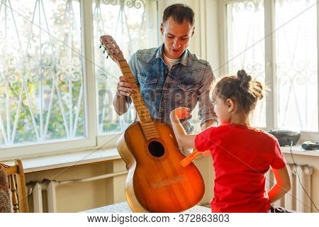 Closeup Mans Hand Changing Strings On His Old Acoustic Guitar.