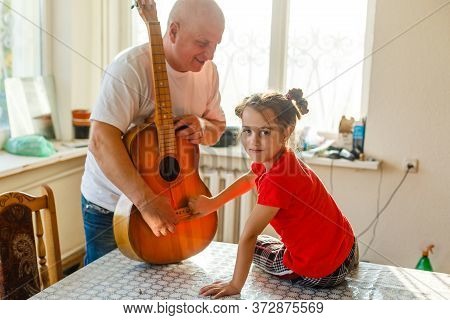 Closeup Mans Hand Changing Strings On His Old Acoustic Guitar.