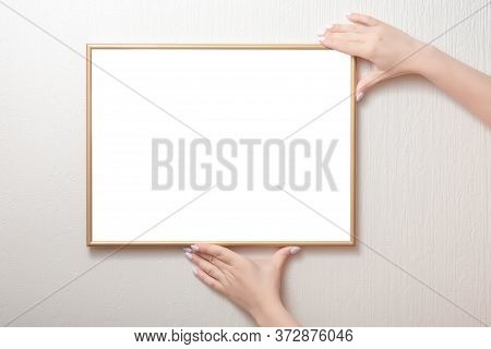 Hanging A Photo Frame Mockup On A White Wall. Picture Frame Mockup